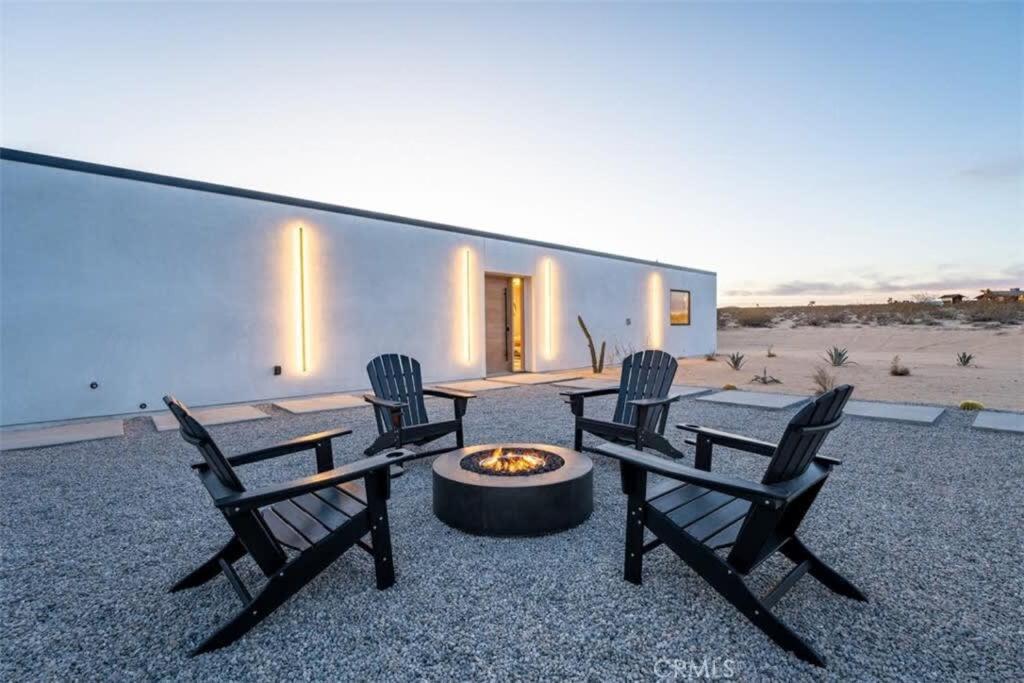 trzy krzesła i miejsce na ognisko przed budynkiem w obiekcie SkyDweller - Joshua Tree Modern w mieście Joshua Tree