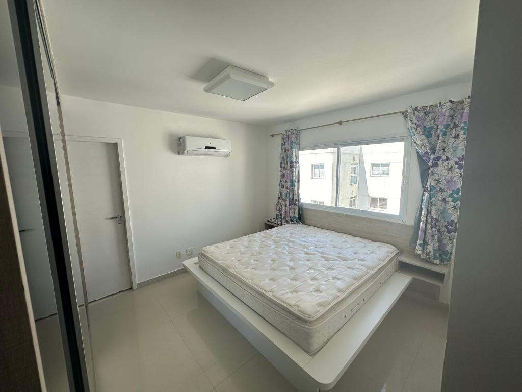 ein kleines Schlafzimmer mit einem Bett und einem Fenster in der Unterkunft Costa Maggiore Residencial Resort in Cabo Frio
