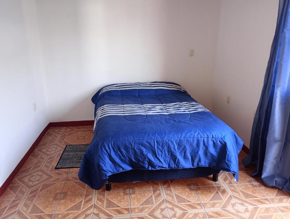 a bedroom with a bed with a blue comforter at Luna y Mar in Oaxaca City