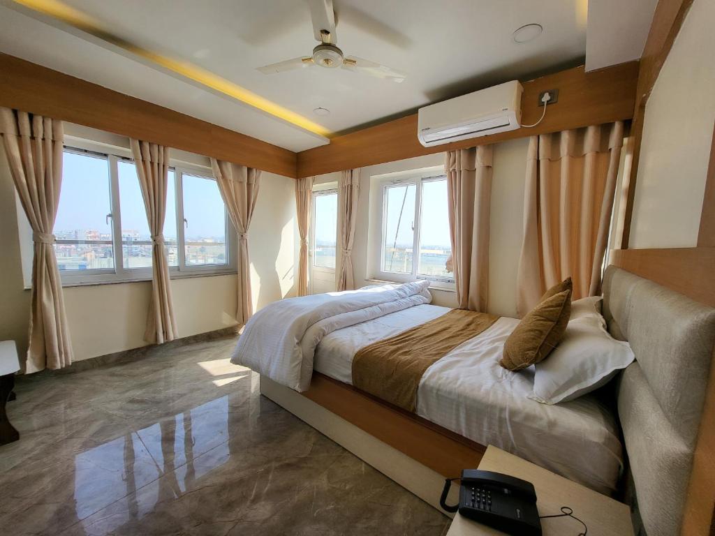 sypialnia z dużym łóżkiem i oknami w obiekcie Anjani Suite w Dźanakpur