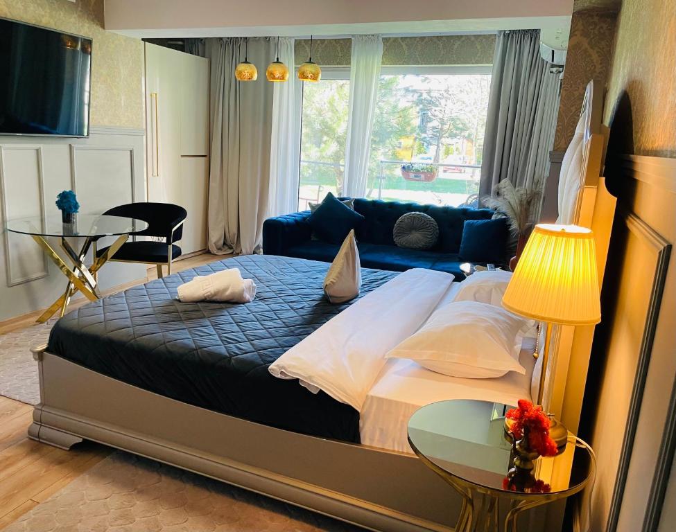 Un dormitorio con una cama grande y un sofá. en Air Residence 4, en Otopeni