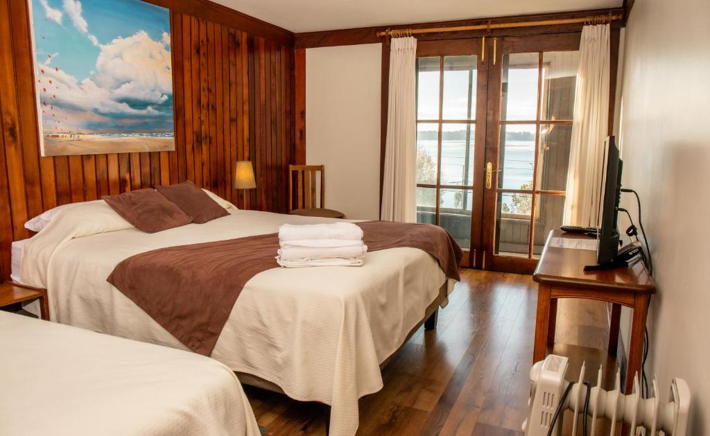 Postel nebo postele na pokoji v ubytování Hotel Hosteria Entre Lagos