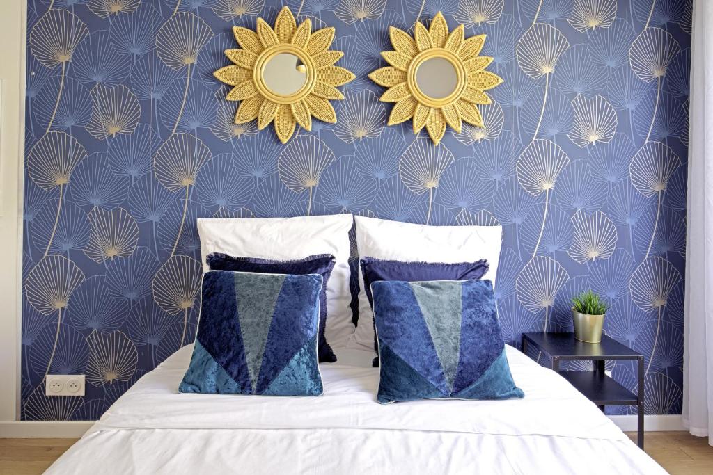 a bedroom with a bed with blue and yellow wallpaper at Equerre - Balcony studio near Buttes Chaumont in Paris