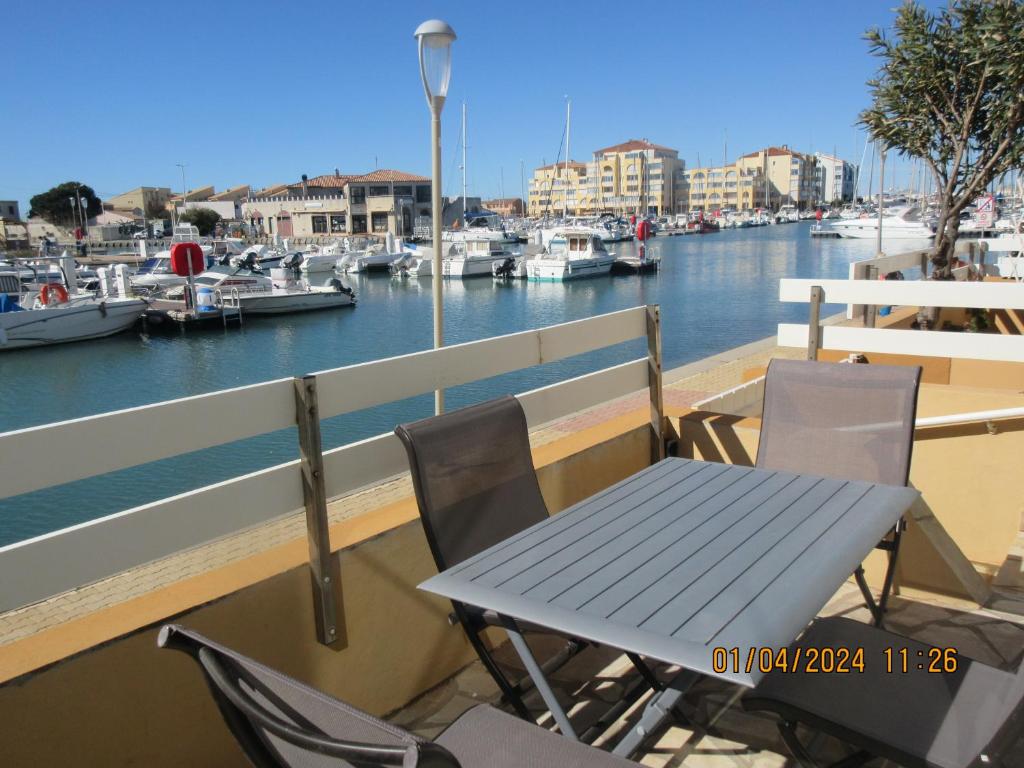 a table and chairs on a balcony with a marina at idéal touristes in Frontignan