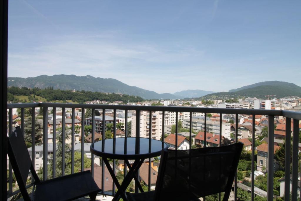 a table and chairs on a balcony with a view at Studio 4 Swimming pool summer parking & superb view! in Aix-les-Bains
