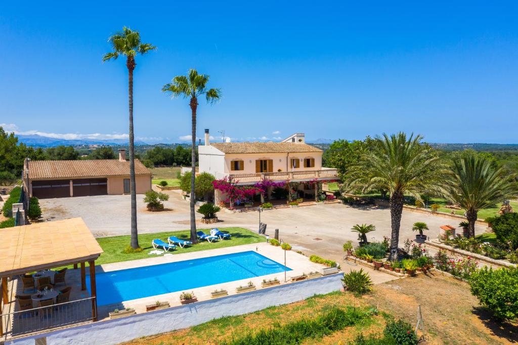 ein Luftblick auf ein Haus mit einem Pool und Palmen in der Unterkunft Villa Darder , Sa garriga in Ariany