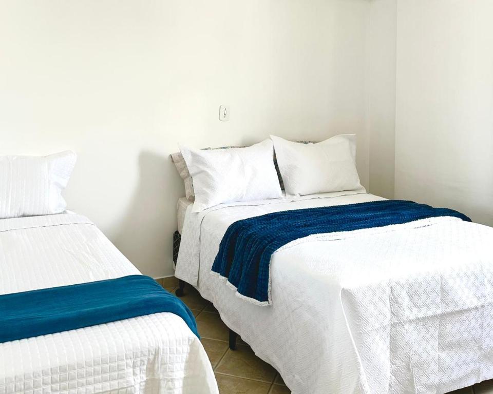 een slaapkamer met 2 bedden met witte en blauwe lakens bij Pérola do Aquarius III in São José dos Campos