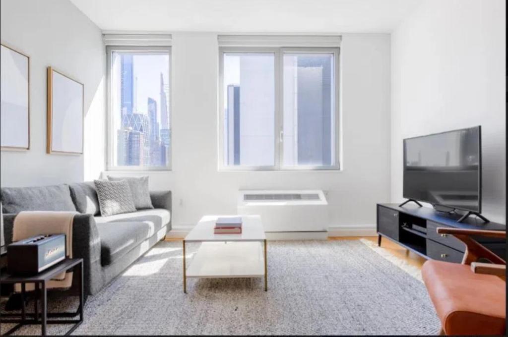 a living room with a couch and a tv at Luxurious Studio Apartment in New York