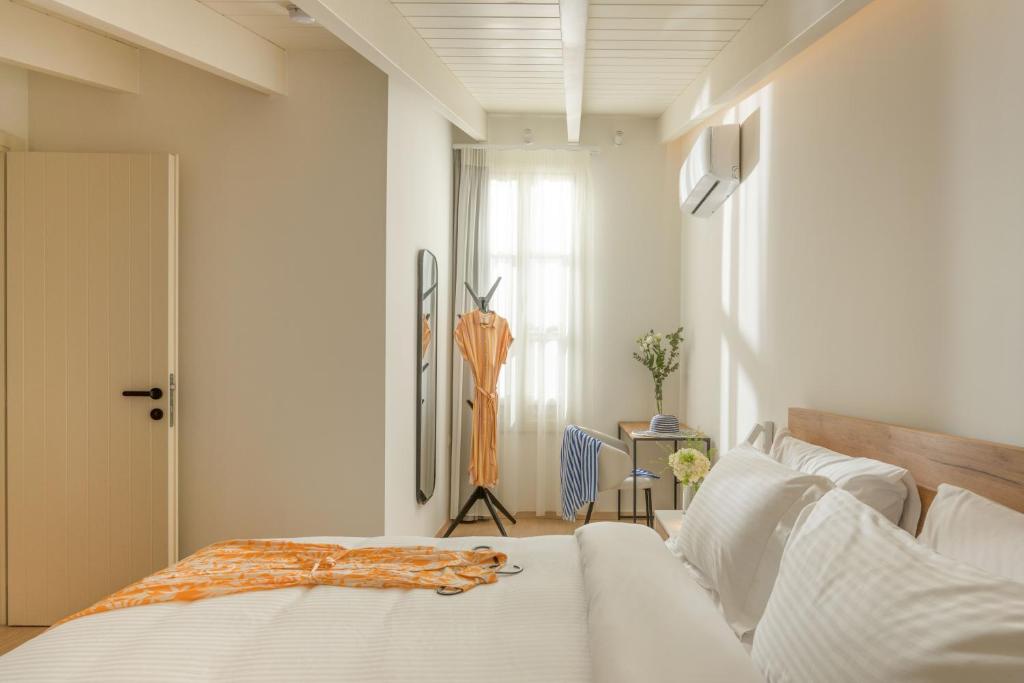 1 dormitorio con cama blanca y ventana en Giustiniani Apartments, en Chios