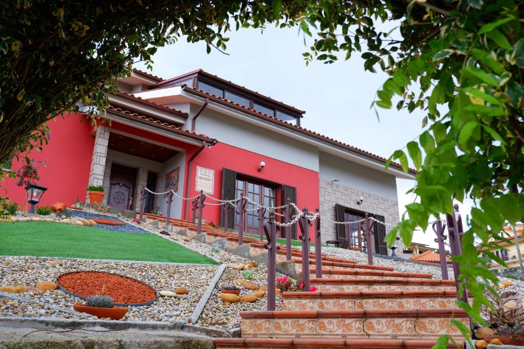 ein rotes Haus mit Treppe davor in der Unterkunft Casa da Fonte in Monção