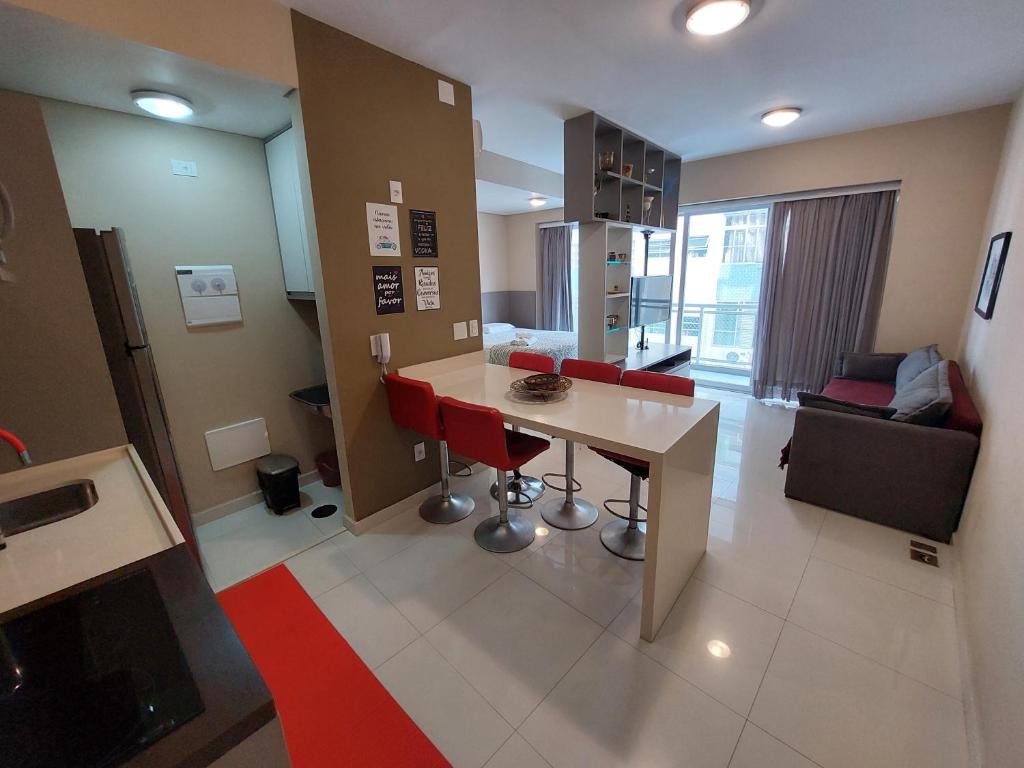 a kitchen with a table and red chairs in a room at Book Santos Unlimited 817 Elegancia Vista Mar in Santos