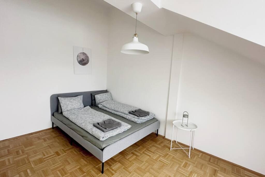 a bed in a room with a white wall at Cozy & New with Balcony View in Vienna