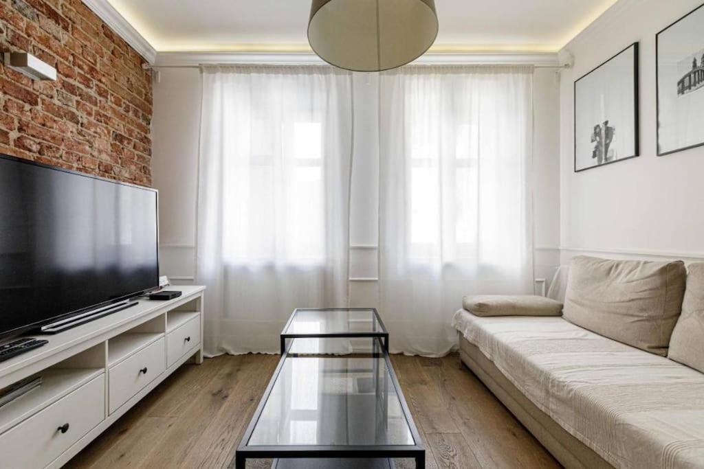 sala de estar con sofá y TV de pantalla plana en Golden Apartments &Uniwersytecka, en Wroclaw