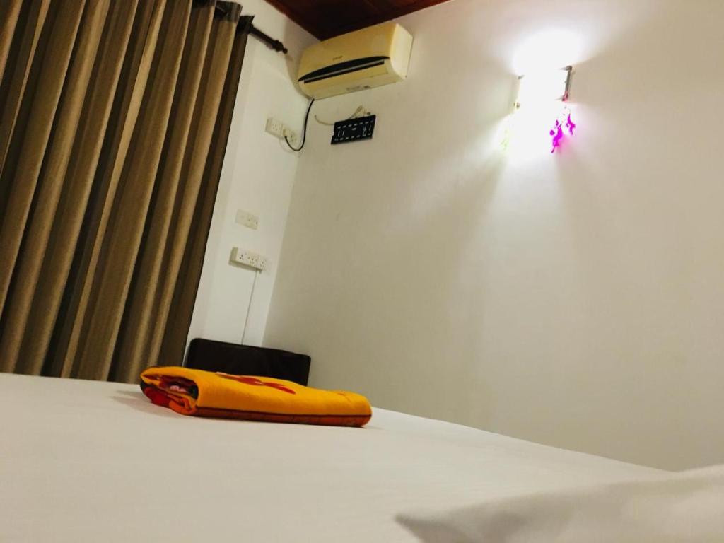 a yellow phone sitting on a bed in a room at The Shade Brothers in Katunayaka