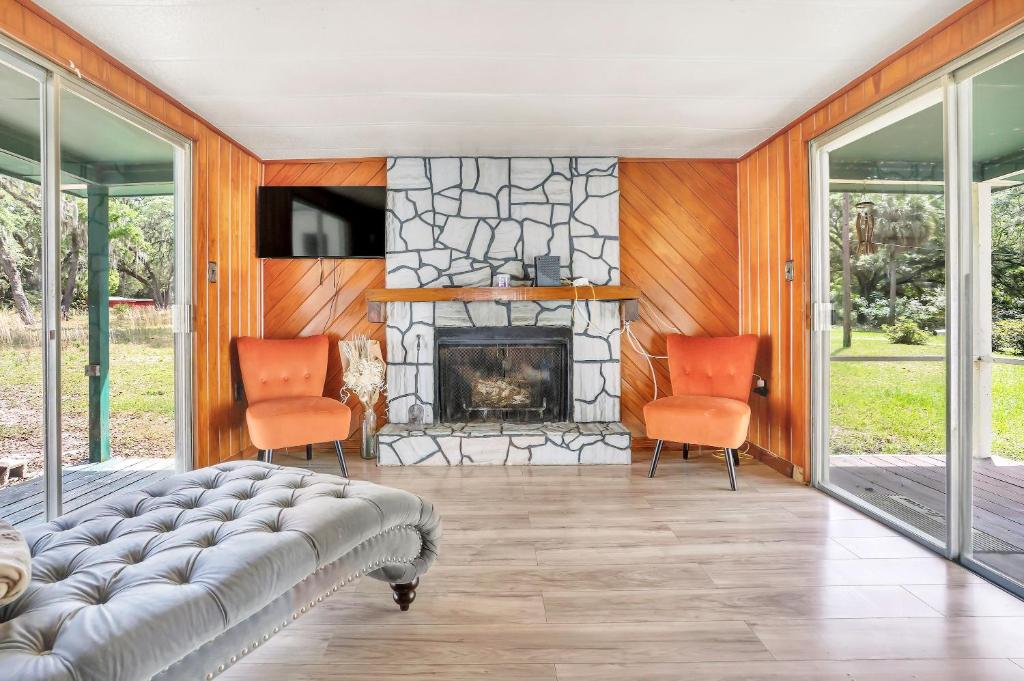 a living room with two chairs and a fireplace at Ocala Farm Lake House in Ocklawaha