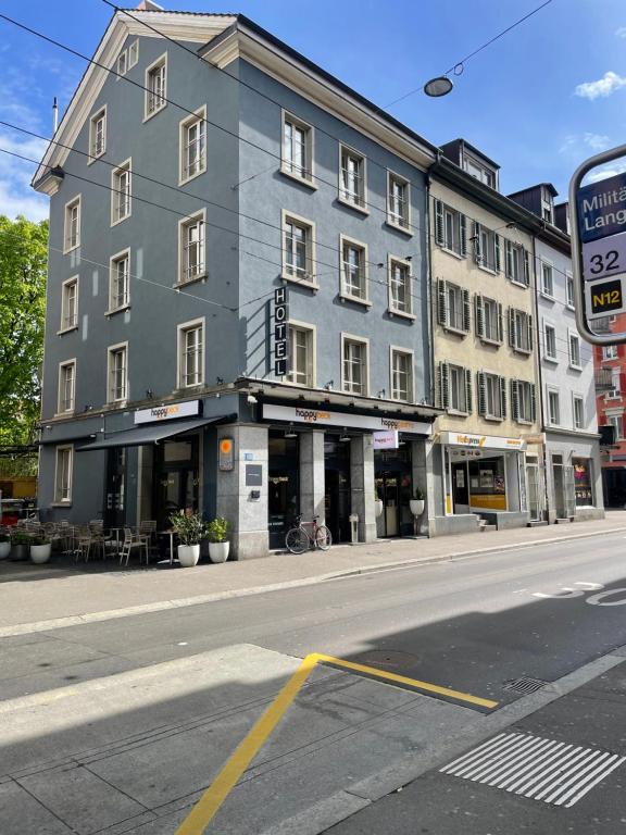 un grande edificio grigio sul lato di una strada di Nani City Hotel a Zurigo