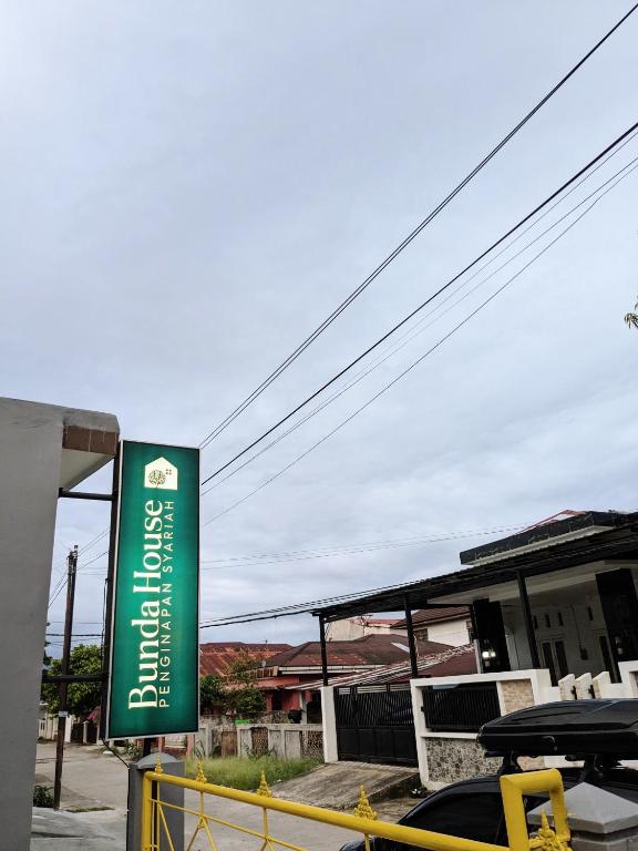 un cartello verde davanti a un distributore di benzina di Bunda House Syariah Lapai a Padang