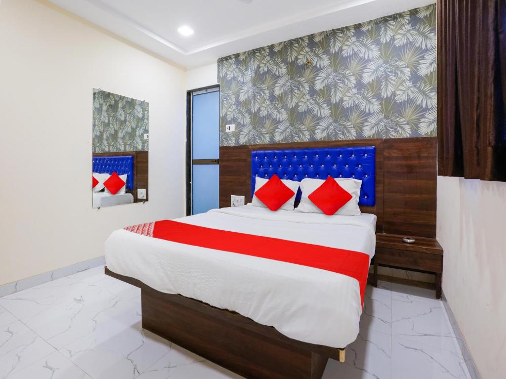 a bedroom with a large bed with red pillows at Hotel King Residency in Mumbai