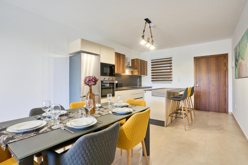 - une salle à manger et une cuisine avec une table et des chaises dans l'établissement Bugibba Terraced New 2 Bedroom 2 Bathroom, à San Pawl il-Baħar