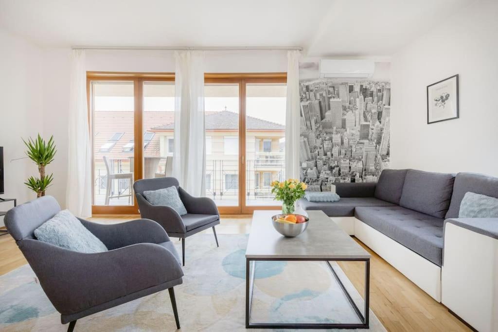 uma sala de estar com um sofá, cadeiras e uma mesa em Dream Home with Grand Terrace in the City Center em Budapeste