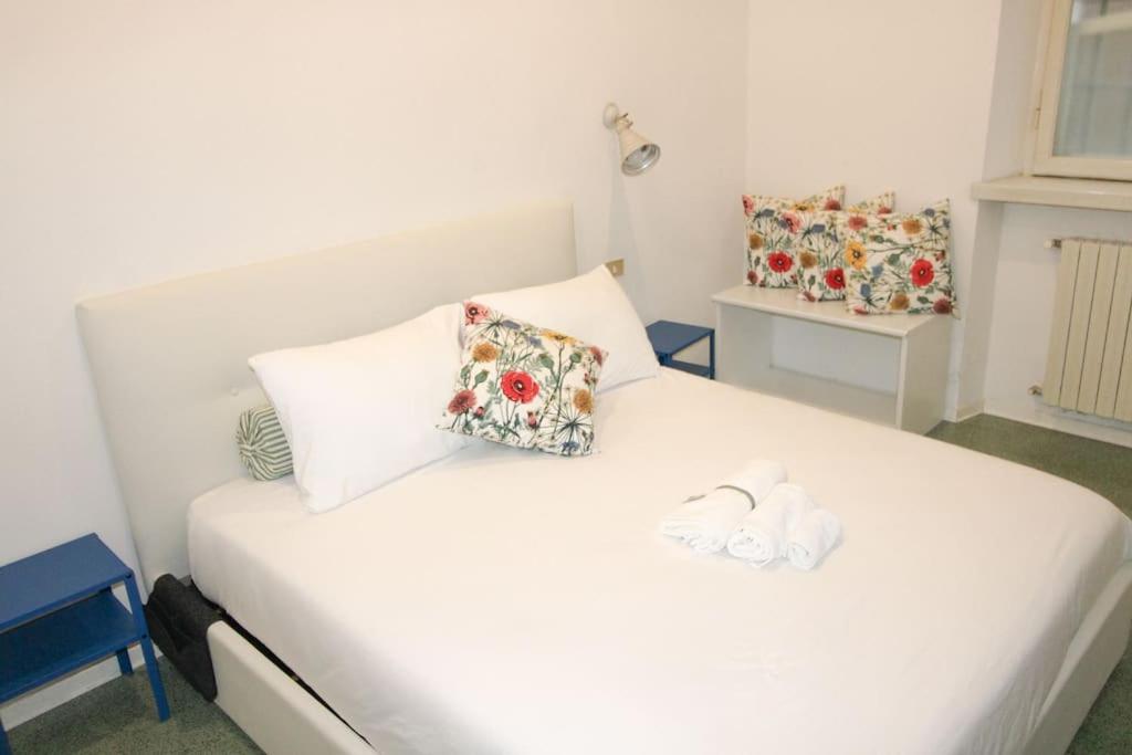 a white bed with two pillows on top of it at Appartamento al Duomo di Parma - posto auto privato prenotabile in Parma