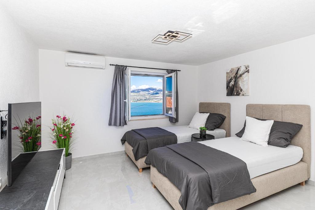 a hotel room with two beds and a television at Apartman Simic in Trogir