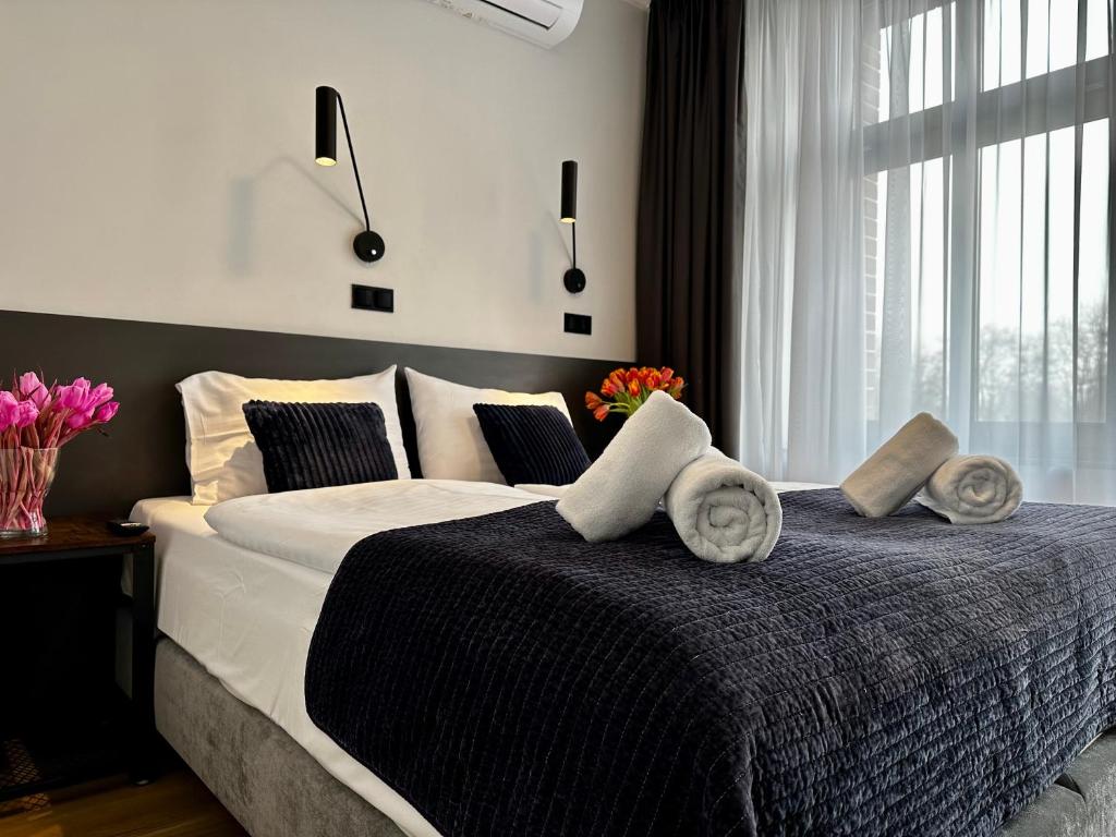 a bedroom with a large bed with towels on it at Motława Riverside Apartments in Gdańsk
