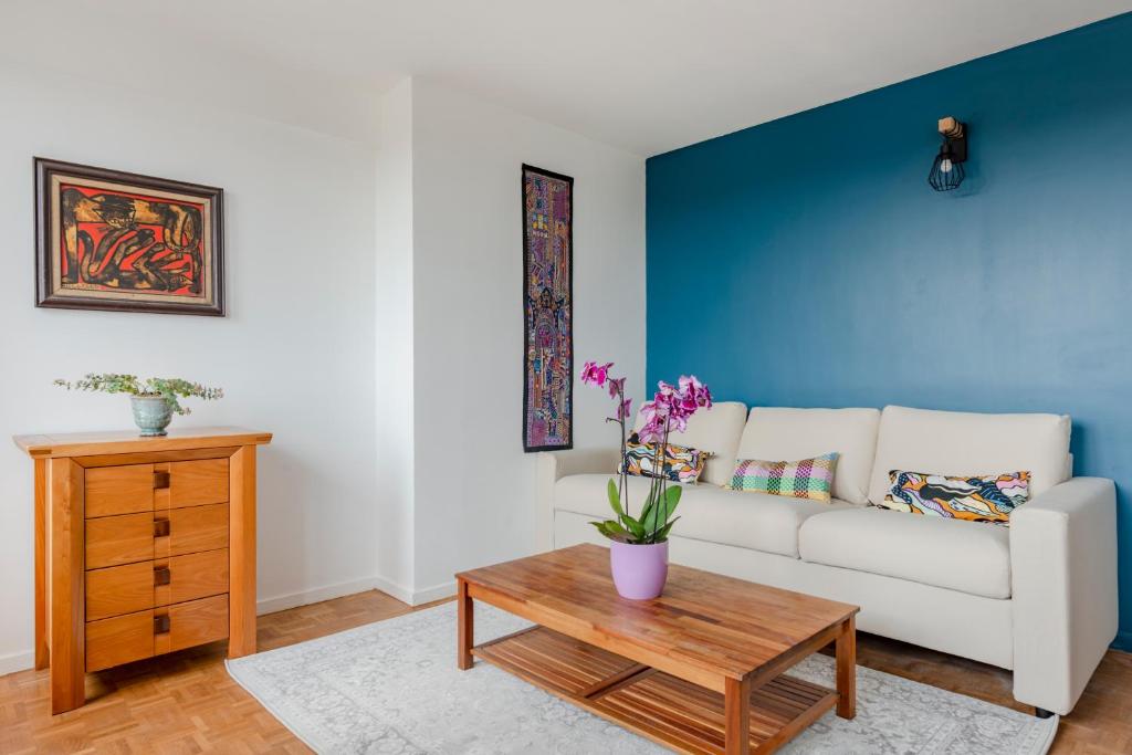 ein Wohnzimmer mit einem weißen Sofa und einem Holztisch in der Unterkunft Bourg la reine cozy spacing apartment in Bourg-la-Reine