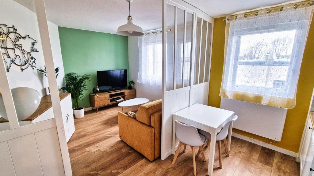 ein Wohnzimmer mit grünen Wänden sowie einem Tisch und Stühlen in der Unterkunft Appartement complet - 1 chambre - Saint-Martin in Brest