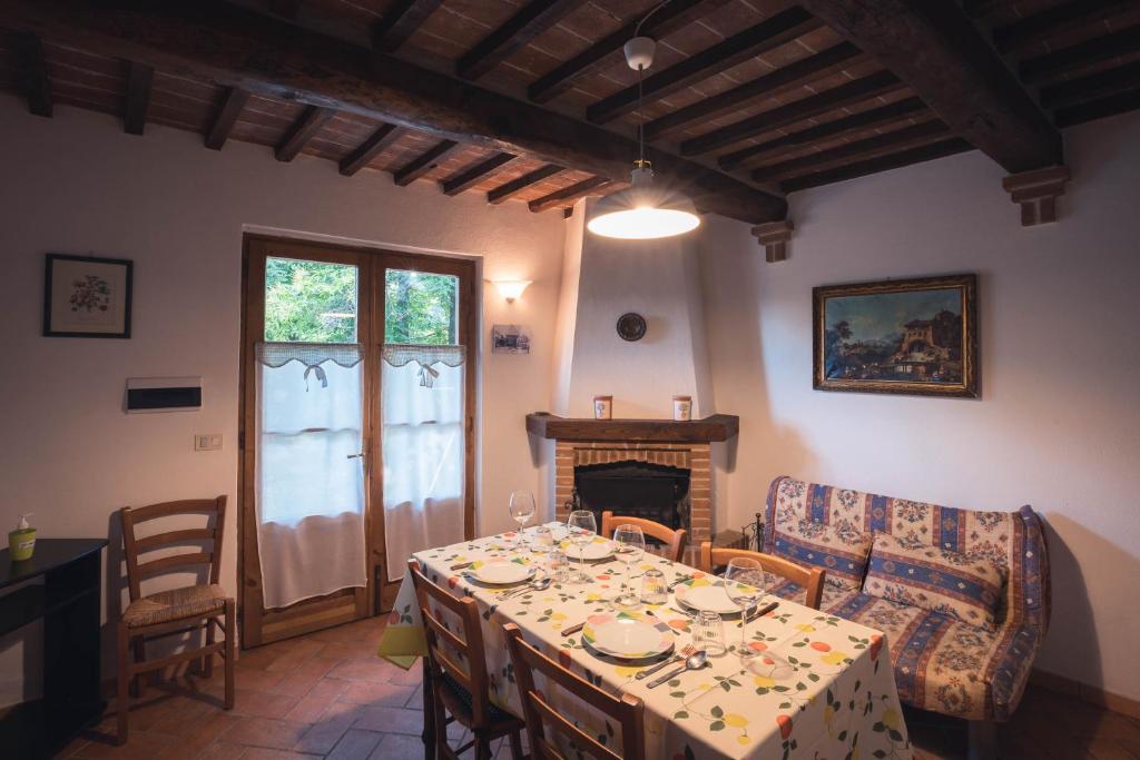 comedor con mesa y chimenea en Nature & Relax in Tuscany - Pagiano 2, en Roccastrada