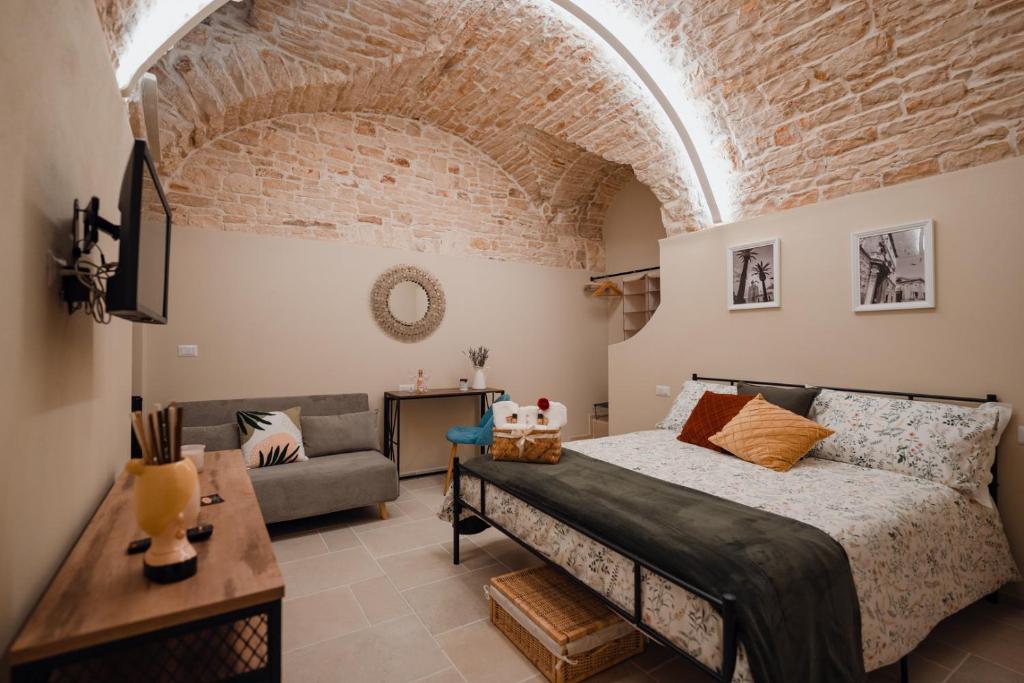 ein Schlafzimmer mit einem großen Bett und einem Sofa in der Unterkunft La Maison di Daniela in Terlizzi