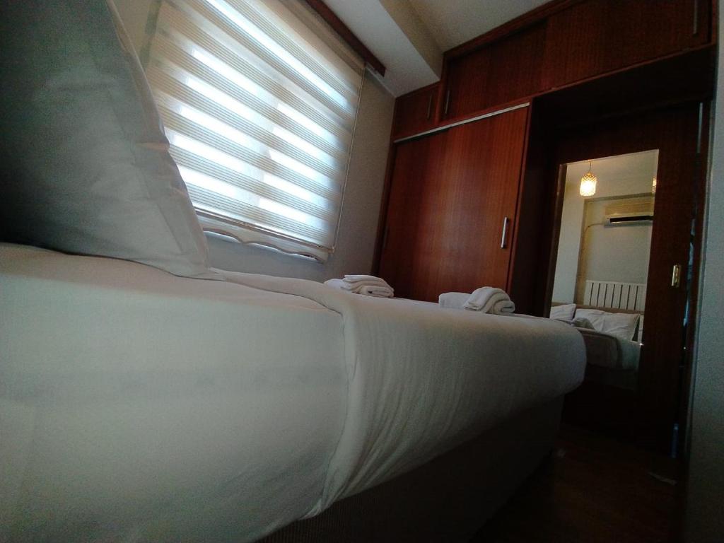 a bedroom with a bed and a window and a mirror at Omr park Suites in Istanbul