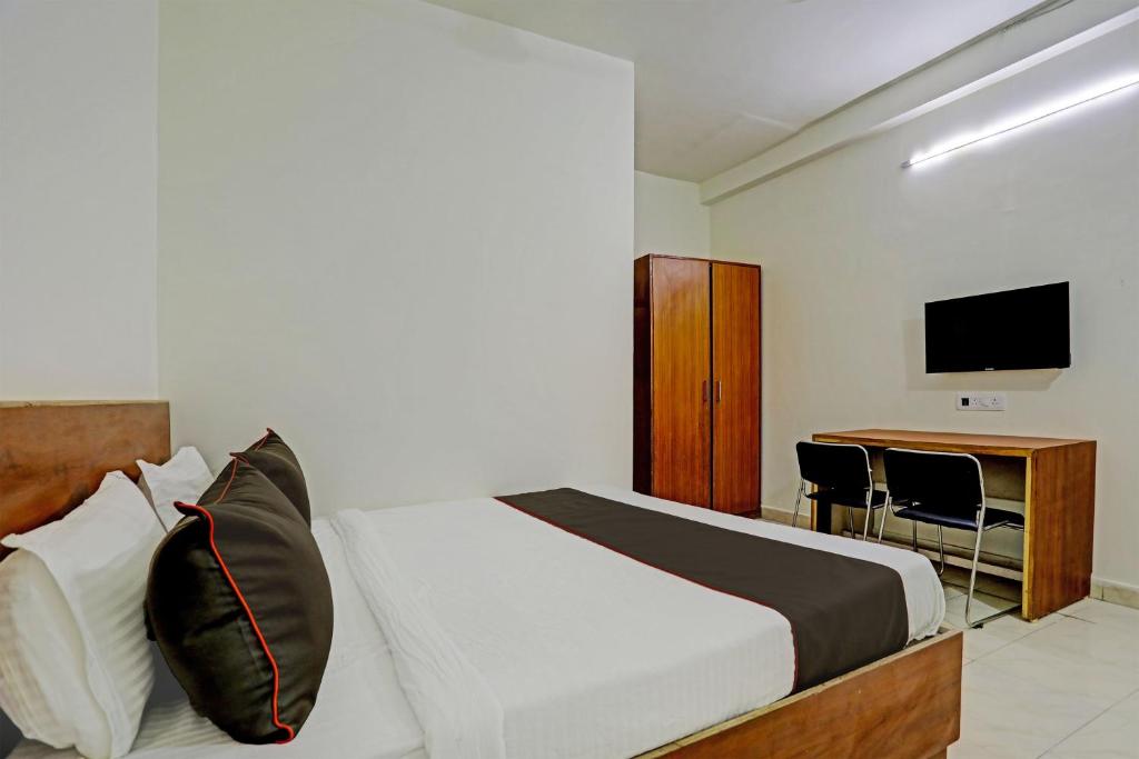 - une chambre avec un lit, un bureau et une télévision dans l'établissement Super Collection O Hotel Aditya Inn, à Bhopal