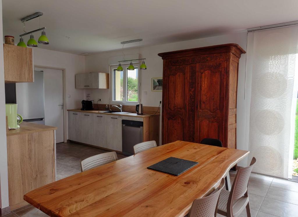 a kitchen with a wooden table and chairs in it at Le Logis d'Emeric avec paisible jardin Clos&Arboré in Loches