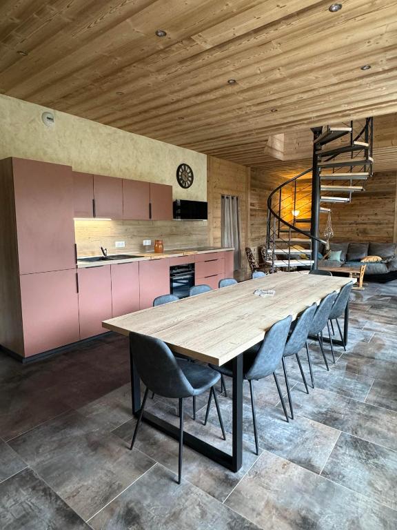 une salle à manger avec une grande table et des chaises en bois dans l'établissement La petite fille des rivières, à Foncine-le-Bas