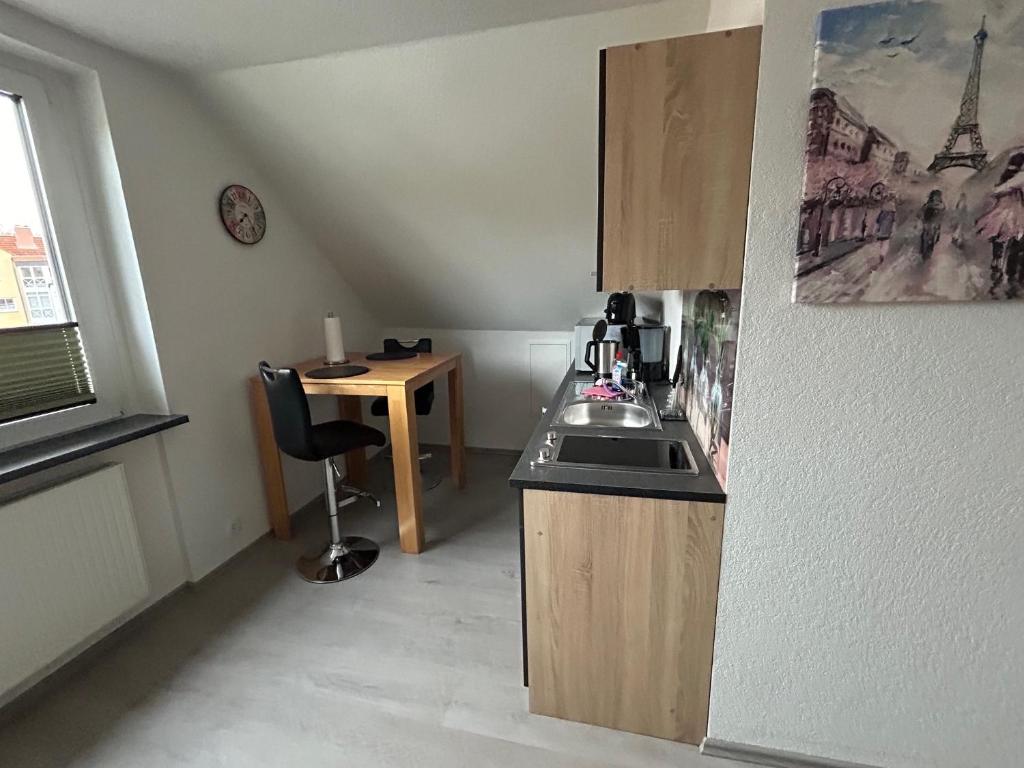 eine kleine Küche mit einem Waschbecken und einem Tisch in der Unterkunft 1 Zi Apartment im Stadtzentrum in Schwalmstadt