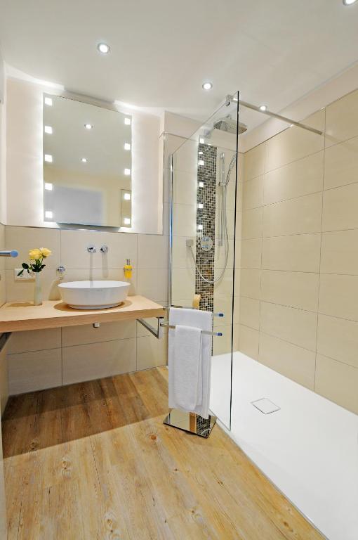 bagno con lavandino e doccia in vetro di Passepartout a Norderney