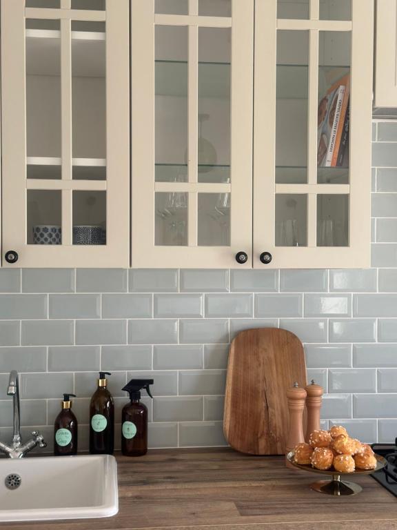 un bancone della cucina con armadi bianchi e lavandino di La Maison de Melman a Quettreville-sur-Sienne