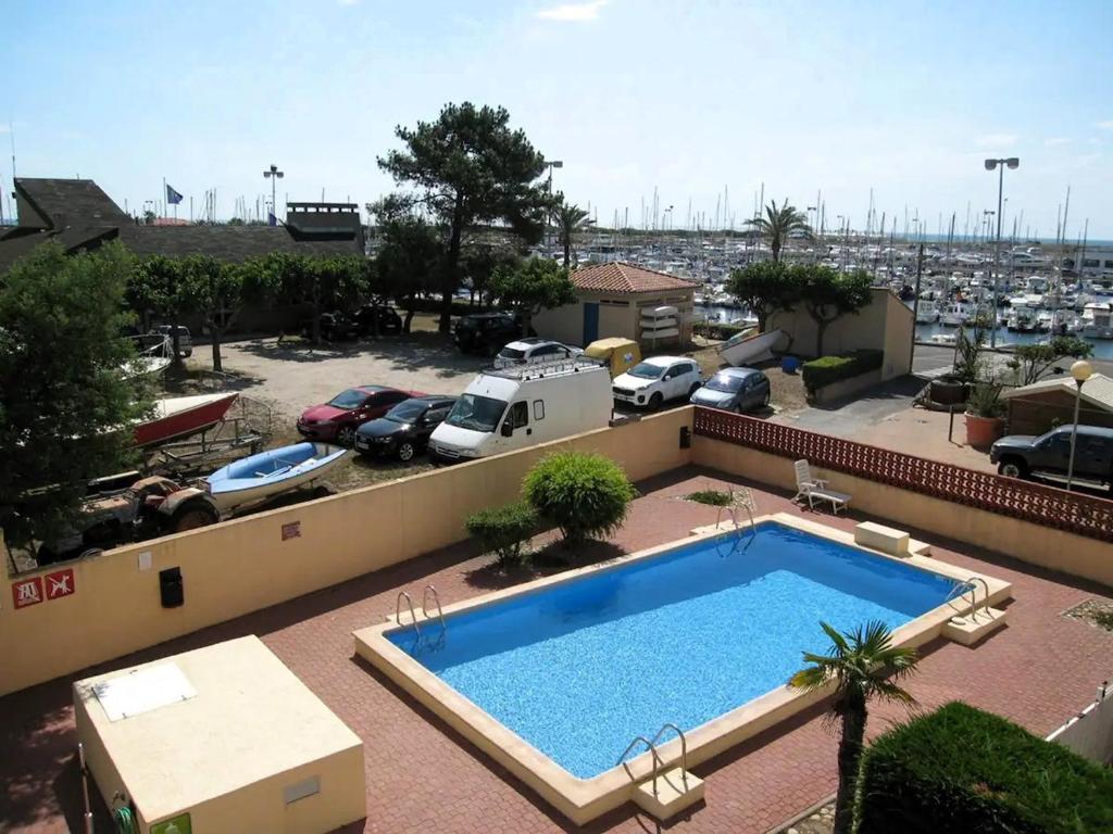 - une piscine au-dessus d'un immeuble avec un parking dans l'établissement Appartement T2 au port, Clim, Fibre, Terrasse, à Saint-Cyprien