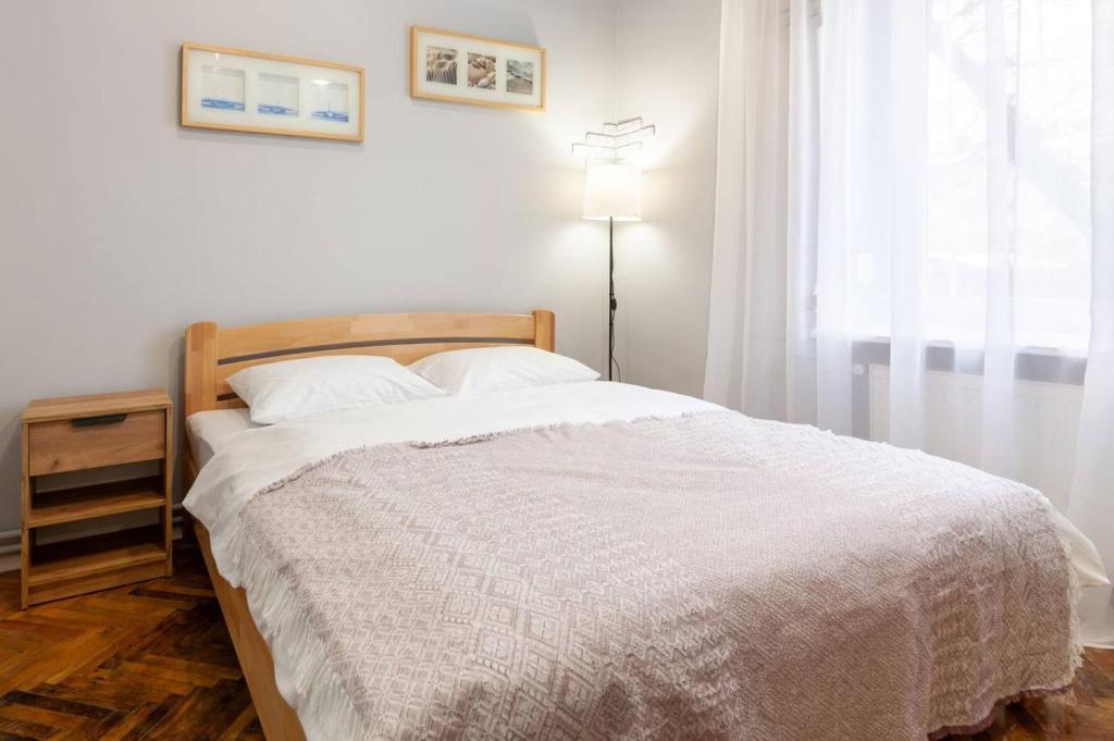 ein Schlafzimmer mit einem Bett mit einer weißen Decke und einem Fenster in der Unterkunft 2 кім квартира подобово на вулиці Ткацькій 8, на 5 осіб - бічна Замарстинівської новобуд Авалон in Lwiw