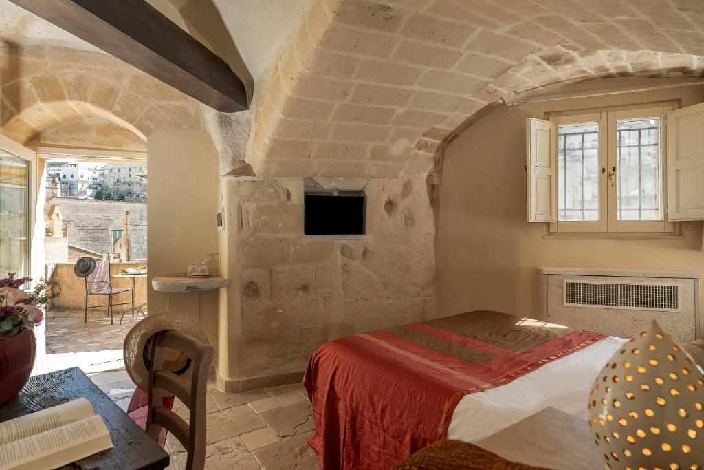 a bedroom with a bed in a stone room at Locanda Di San Martino Hotel & Thermae Romanae in Matera