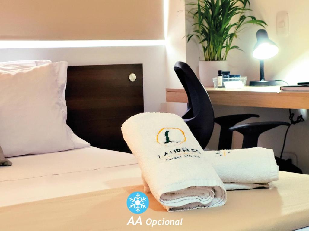 um quarto de hotel com uma toalha numa cama em Laureles Guest House em Medellín