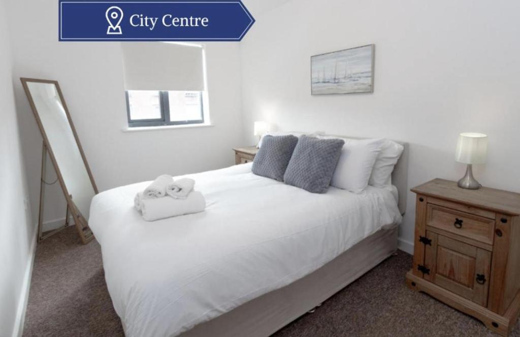 a bedroom with a white bed with two towels on it at Chic 1Bed Apt near Liverpool CC in Liverpool