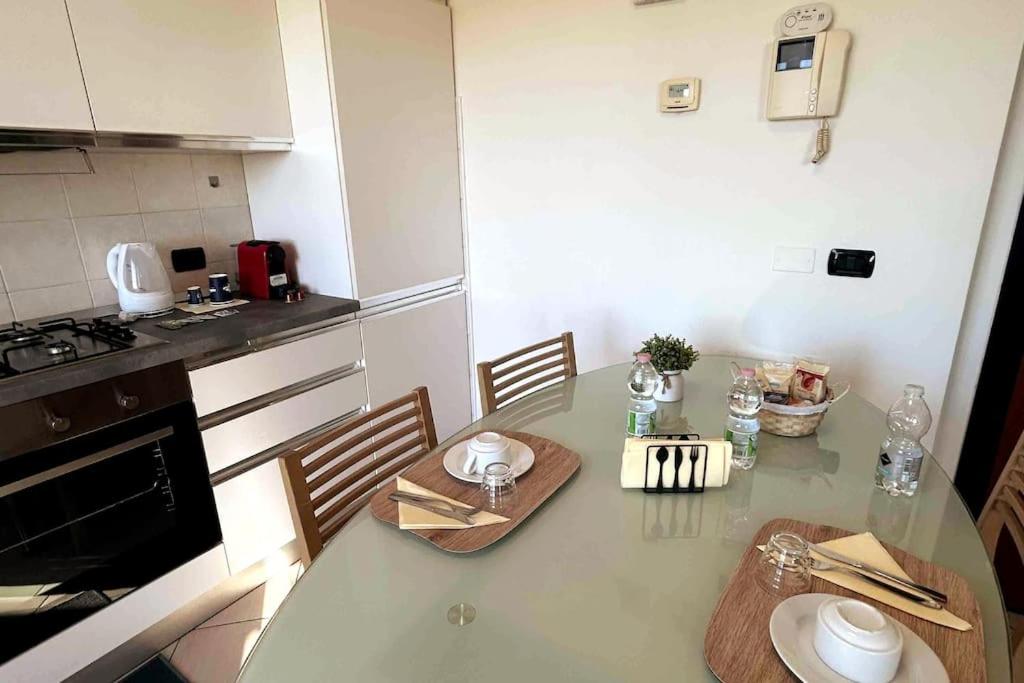 een keuken met een tafel met stoelen en een fornuis bij App 27 Parcheggio Privato - Accogliente Monolocale in Monza