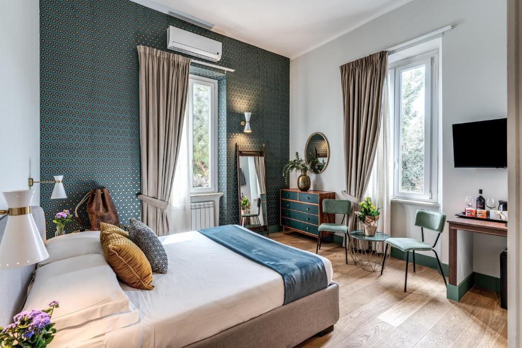 um quarto de hotel com uma cama, uma secretária e cadeiras em Tree Charme em Roma