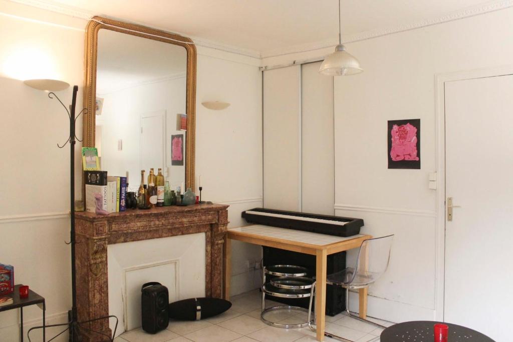 a room with a mirror and a table and a fireplace at Apartment near the Marais in Paris