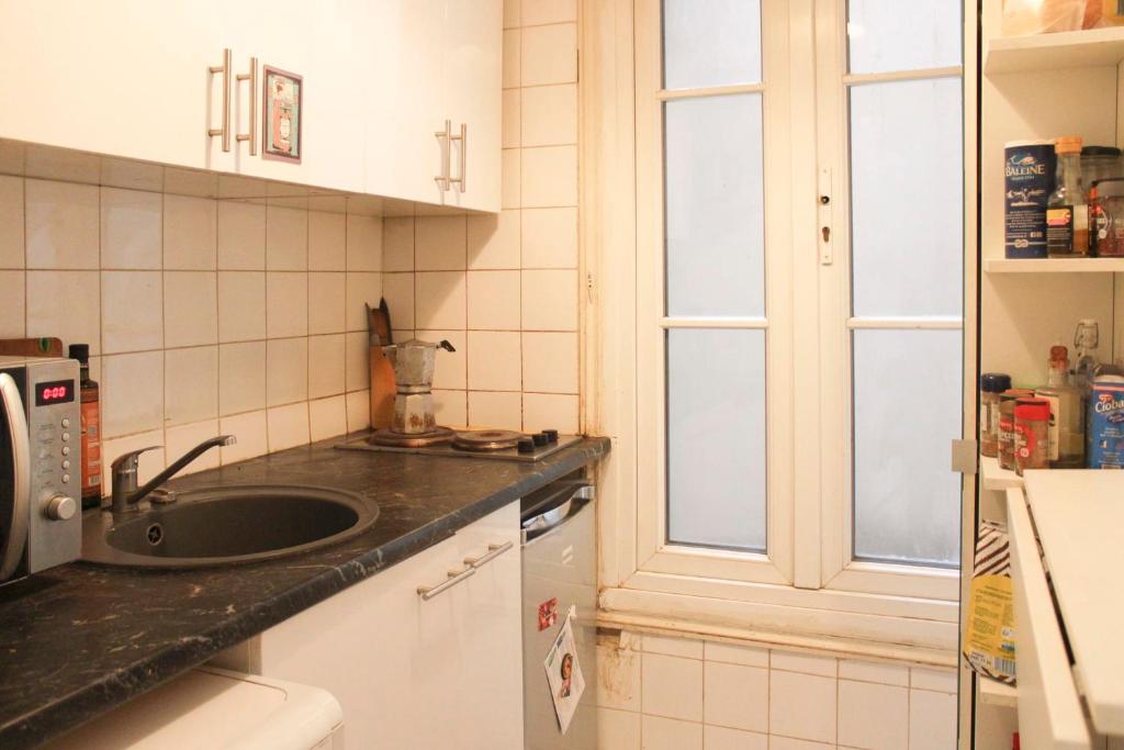 a kitchen with a sink and a window at Apartment near the Marais in Paris