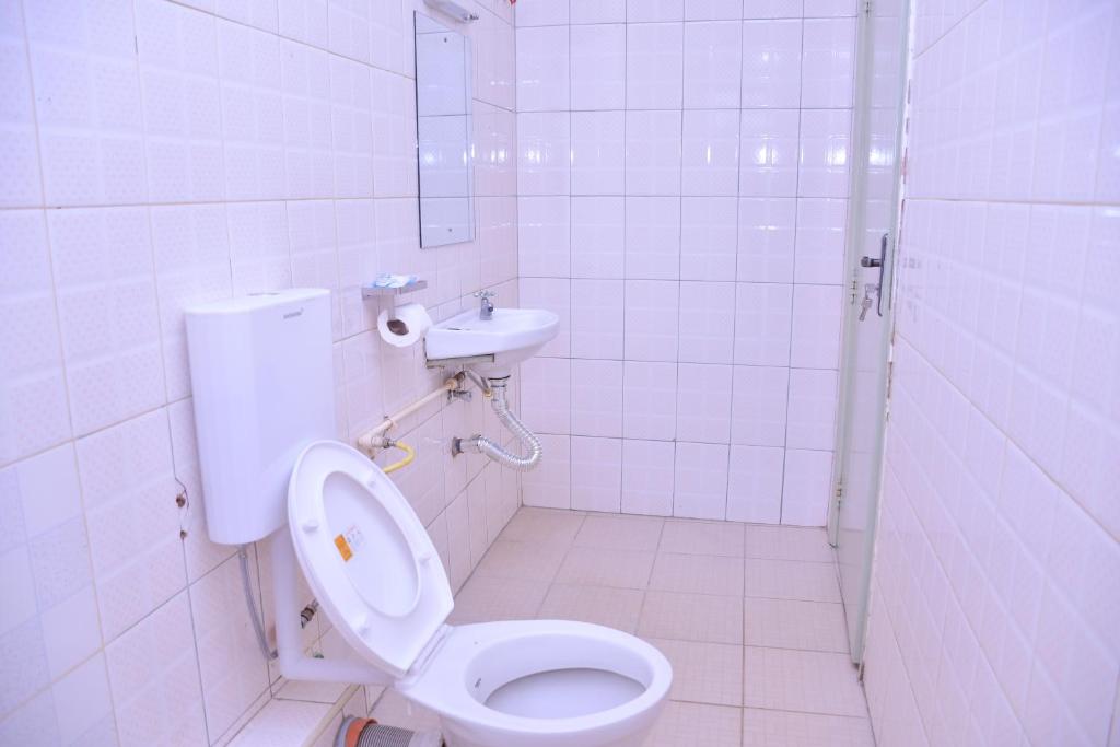 ein weißes Bad mit einem WC und einem Waschbecken in der Unterkunft Peridot Suites in Nairobi