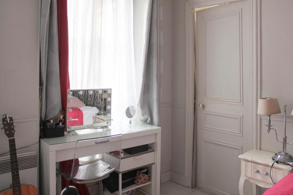 a bathroom with a vanity and a mirror on a table at Apartment near the Marais in Paris