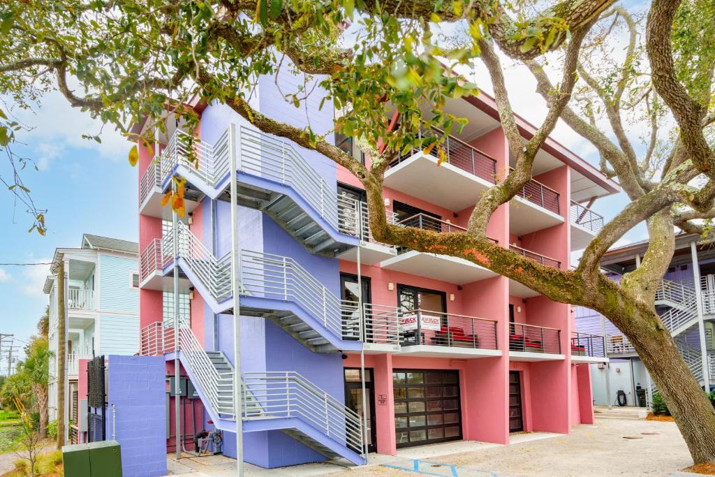 a pink and purple building with stairs at Boutique Vera Hotel in the Heart of Folly Beach in Folly Beach